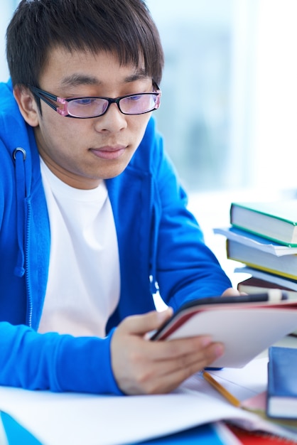 Free photo concentrated boy using his digital tablet