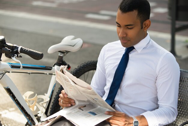 Concentrated Businessman Reading News in Park