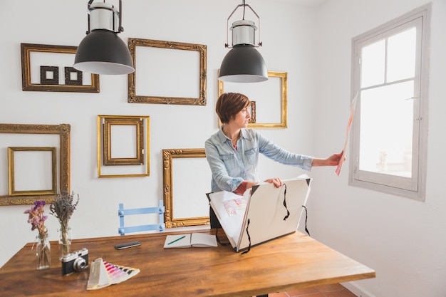 Concentrated businesswoman checking a design next to the window