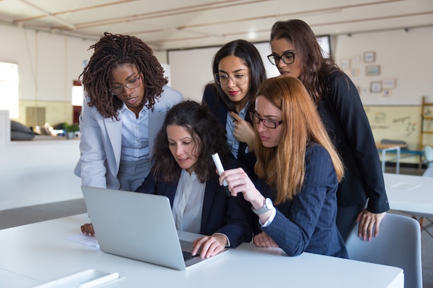 Foto gratuita donne di affari concentrate che utilizzano computer portatile nell'ufficio