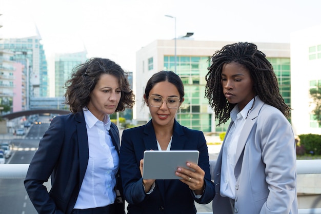 Concentrated businesswomen with digital tablet
