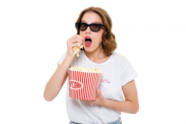 Concentrated caucasian woman holding pop corn wearing 3d glasses