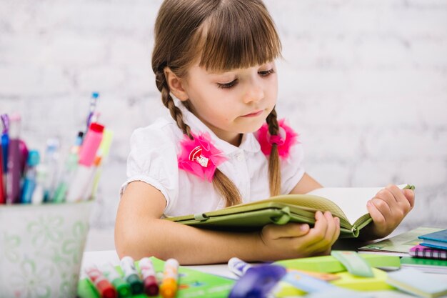 Concentrated child reading book at table