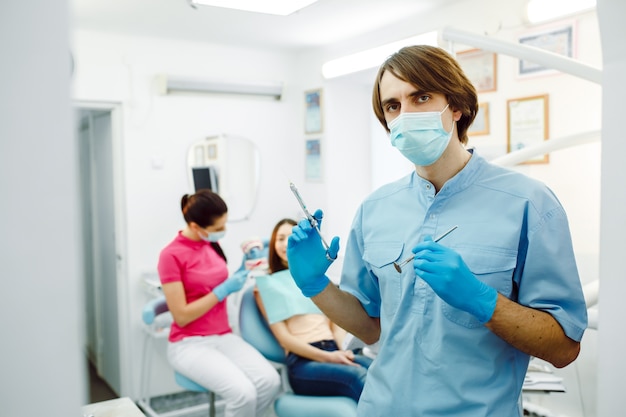 Foto gratuita dentista concentrato presso la clinica