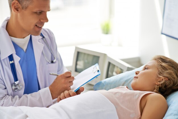 Concentrated doctor taking notes of the diagnosis