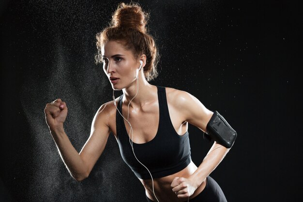 Concentrated fitness woman running in studio