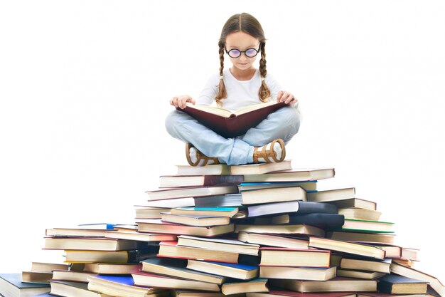 Концентрированные девочка окружении книг