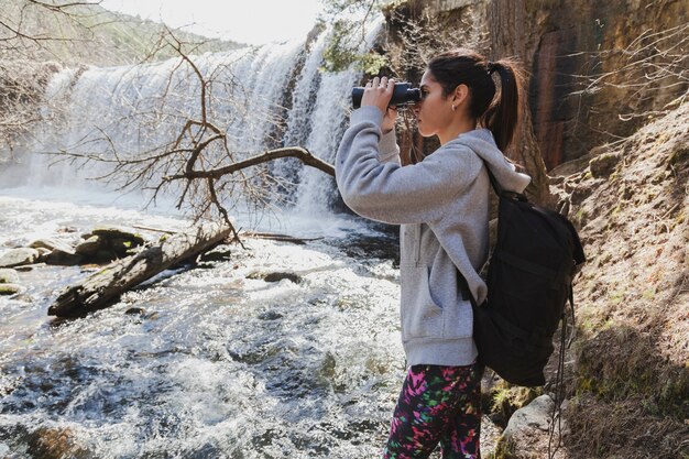 Concentrated girl with binoculars outdoors