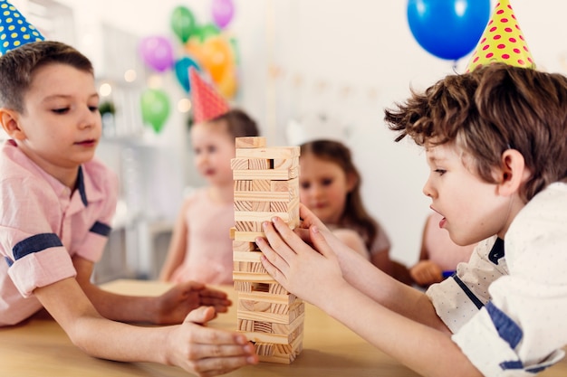 Concentrated kids in colored caps playing game 