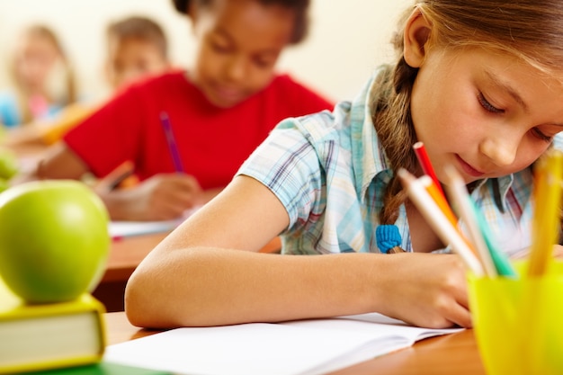 Concentrated little girl doing homework