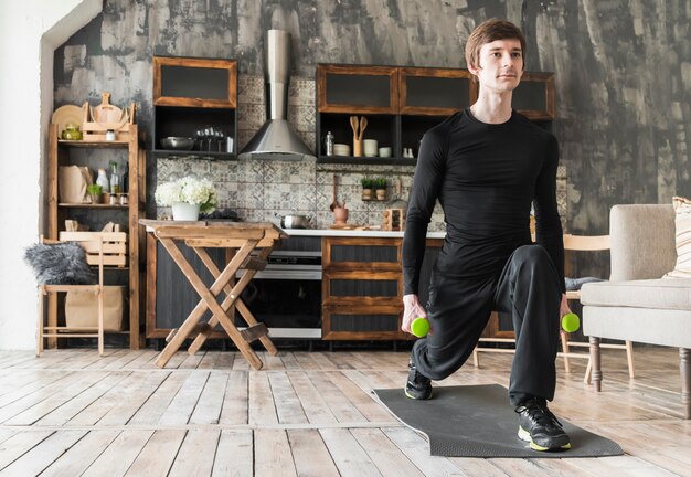 Concentrated male doing exercises with dumbbells