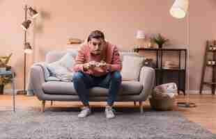 Free photo concentrated man on couch playing