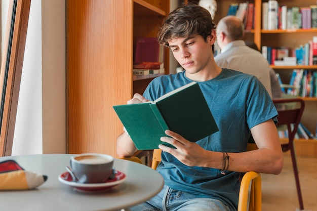 Concentrated man enjoying reading book