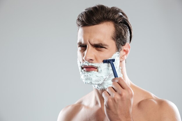 Concentrated man has a shave