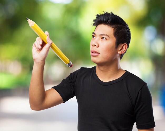 Concentrated man typing in the air with a large pen