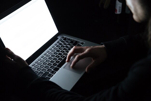 Concentrated man using laptop computer at home