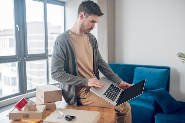 Concentrated online store employee working on the laptop