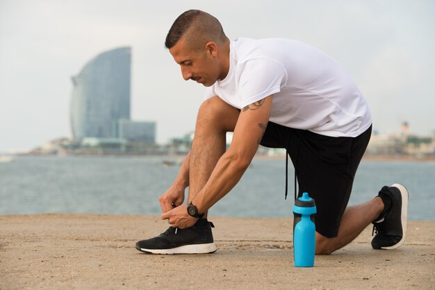 Concentrated runner tying laces on sneakers