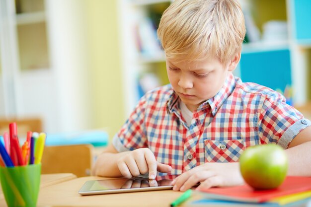 Concentrated schoolboy with a tablet