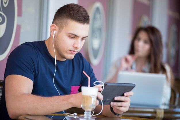 Concentrated teen listening to music with his tablet