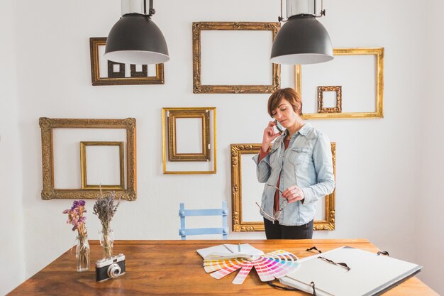 Concentrated woman talking on the phone and looking at a color palette