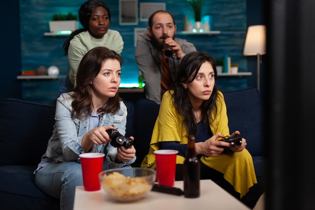 Concentrated women relaxing on couch playing video games using controller