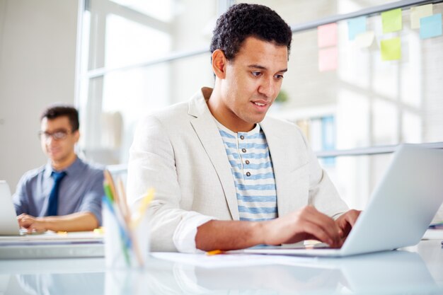 Concentrated worker typing on laptop