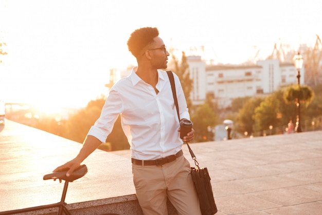 Concentrated young african man in early morning with bicycle