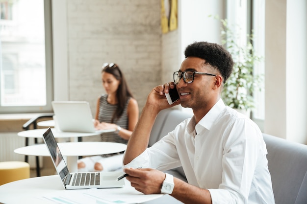 Coworking di seduta concentrato del giovane uomo africano