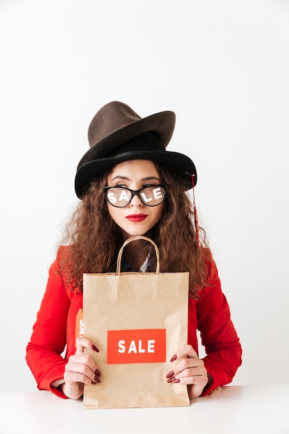 Free photo concentrated young caucasian lady holding shopping bag