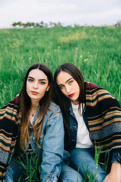 Foto gratuita concentrato di giovani donne con coperta che guarda l'obbiettivo