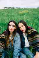 Free photo concentrated young ladies with blanket looking at camera