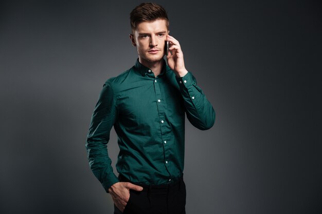 Concentrated young man standing isolated over grey