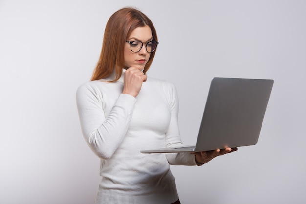 Concentrated young woman using laptop