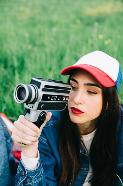 Concentrated young woman using vintage camera 