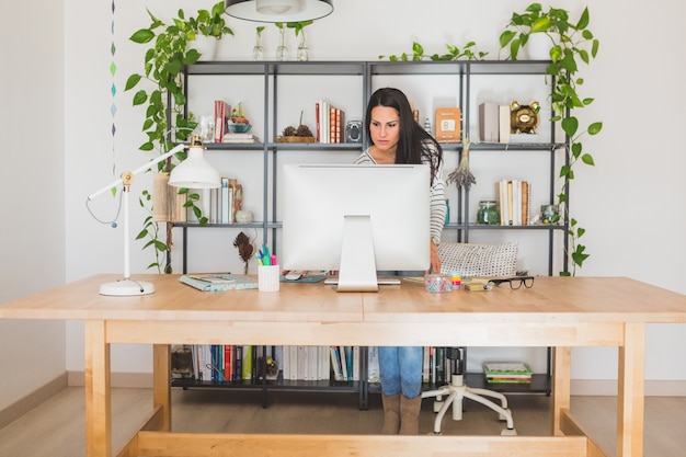 Foto gratuita concentrato giovane donna che lavora con il computer