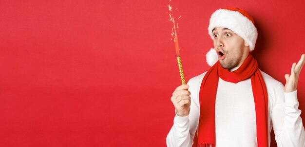 Concept of christmas winter holidays and celebration closeup of amazed handsome man in santa hat and...