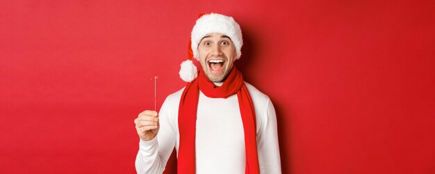 크리스마스 겨울 휴가의 개념과 산타 모자를 쓴 행복한 잘생긴 남자의 축하 근접 촬영 및 ...