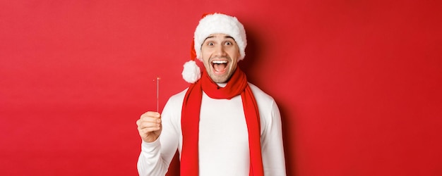 クリスマスの冬の休日の概念とサンタの帽子と...で幸せなハンサムな男のお祝いのクローズアップ