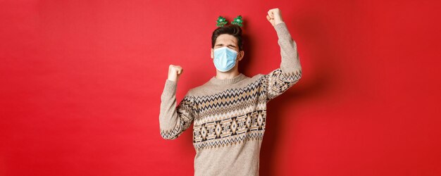 Concept of coronavirus winter holidays and social distancing image of excited and happy man in medic