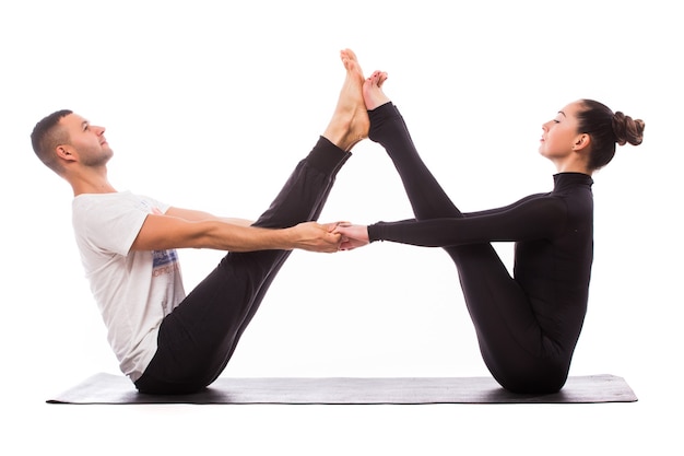 Понятие о парах йоги. Молодая здоровая пара в позе йоги на белом фоне