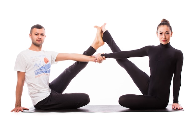 Concept of couple yoga. Young healthy couple in yoga position on white background