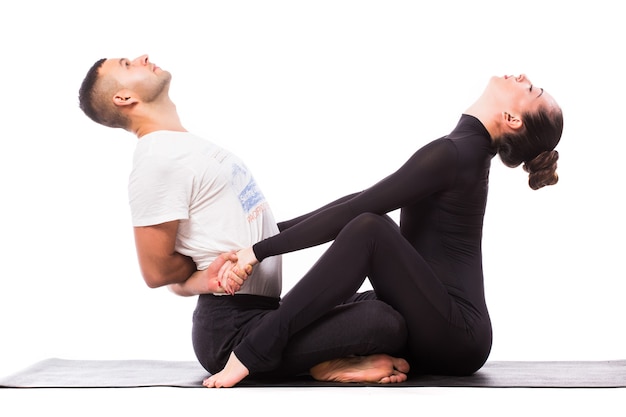 Concept of couple yoga. Young healthy couple in yoga position on white background