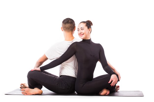 Concept of couple yoga. Young healthy couple in yoga position on white background