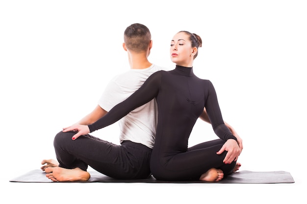 Concept of couple yoga. Young healthy couple in yoga position on white background