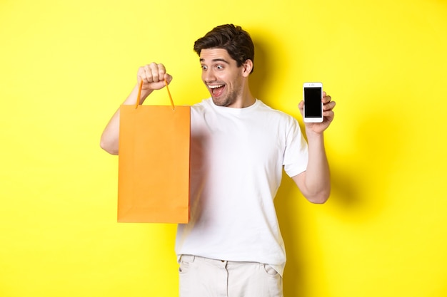할인 온라인 뱅킹 및 캐쉬백의 개념 행복한 남자는 상점에서 물건을 사고 쇼를 보고 있습니다.