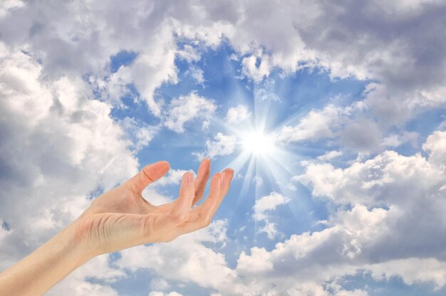 Концепция. руки касаются превращается в небо на солнечном фоне пасмурное небо