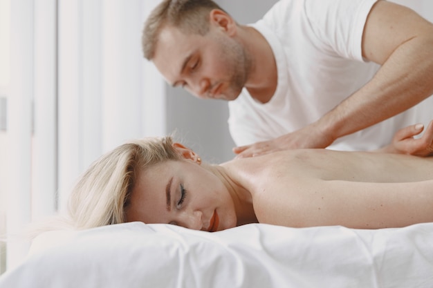 Concept of healthcare and female beauty. Masseuses make a massage of a girl. Woman in a spa salon.