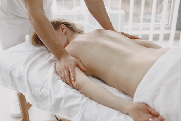 Concept of healthcare and female beauty. Masseuses make a massage of a girl. Woman in a spa salon.