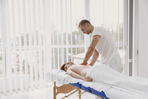 Concept of healthcare and female beauty. Masseuses make a massage of a girl. Woman in a spa salon.